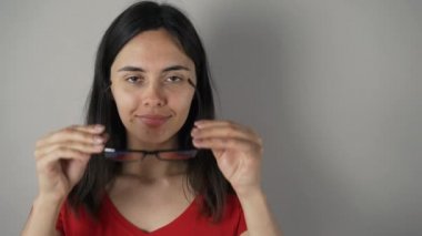 gri duvar arka plan üzerinde izole gözlük ile kız.