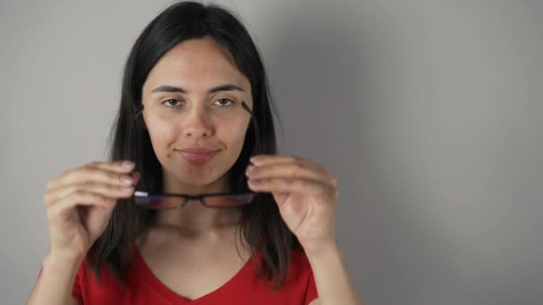 Chica con gafas aisladas sobre fondo de pared gris . — Vídeos de Stock