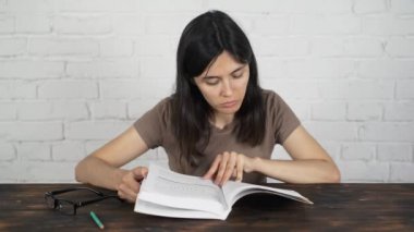 Bir kitap okuma gözlükleri ile beyaz bir masada oturan kız günlüğü. Kötü görme.