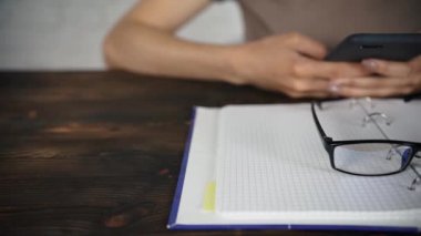 Bir kitap okuma gözlükleri ile beyaz bir masada oturan kız günlüğü. Kötü görme.