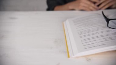 Bir kitap okuma gözlükleri ile beyaz bir masada oturan kız günlüğü. Kötü görme.