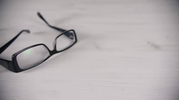 Vista frontal de óculos de leitura na mesa branca . — Vídeo de Stock