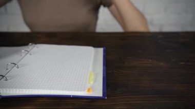 Bir kitap okuma gözlükleri ile beyaz bir masada oturan kız günlüğü. Kötü görme.