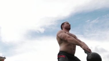 Her iki el ile kettlebells alarak ve ağır çekimde savurma güçlü bir adam, crossfit,
