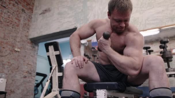 Typ, der die Arme mit Hanteln in den Händen beugt, Gym-Workout, klobige Körpernahaufnahme — Stockvideo
