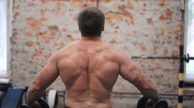 Adam silah onun elleri, jimnastik salonu iş, iri cesedi closeup dumbbells ile esneme.