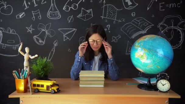 Ritratto di una bella studentessa, pensando di scegliere una professione, sullo sfondo di una tavola nera con un globo. Concetto: idee, scuola, università, istruzione . — Video Stock