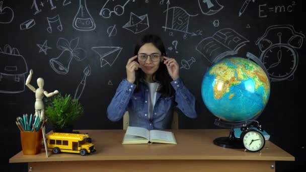 Portret pięknej uczennica student, myśląc o wyborze zawodu, na tle czarny deska z globusem. Koncepcja: pomysły, Szkoła, Uniwersytet, edukacja. — Wideo stockowe