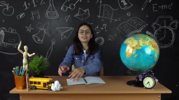 Porträtt av en vacker Skolflicka student, funderar på att välja ett yrke, på bakgrunden av en svarta tavlan med en jordglob. Koncept: idéer, skola, universitet, utbildning. — Stockvideo