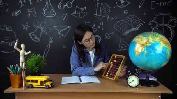 Retrato de uma bela estudante, pensando em escolher uma profissão, no fundo de uma placa preta com um globo. Conceito: ideias, escola, Universidade, educação . — Vídeo de Stock