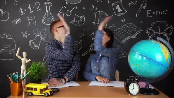 Young students, schoolchildren study hard in the library. University students conduct research in the library with books on the table. For the concept of diversity the school of education — Stock Video