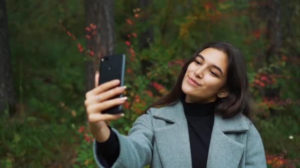 Felice giovane donna che invia sms, sms nel parco — Video Stock