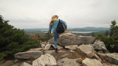 Kadın turist üstte mutlu ve kutluyor başarıdır. Dünya üzerinde bir kot ceket bir kadında muzaffer bir hareketle sevinir