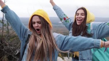 Dans ve silah üstünde güzel dağ tepe üzerinde gökyüzü günbatımı yetiştirme iki genç mutlu kadın.