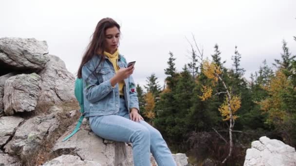 Genç kız sohbet görüntülü sohbet cep telefon arkadaş bağlantı dağlar. — Stok video
