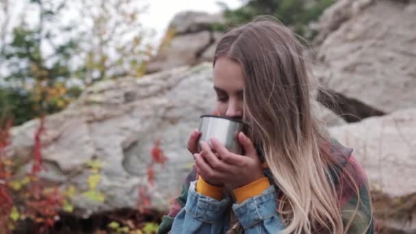 Turist dricka te från en mugg av en termos mot bergen — Stockvideo