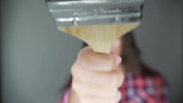 Une femme en vêtements de tous les jours, dansant et chantant, tenant une brosse à réparer, des outils pour réparer les pièces d'appartement, isolée sur un fond gris. Réparation de maison — Video