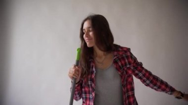 Hippi kız ekose gömlek hafif gri arka plan üzerinde dans..