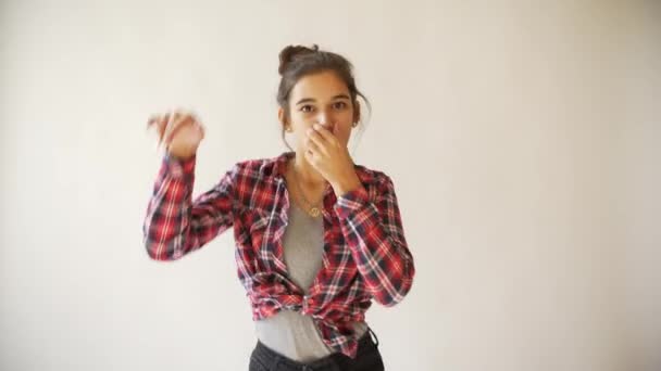 Hipster meisje dansen in plaid shirt op lichte grijze achtergrond. — Stockvideo