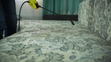 Temizlik şirketi koltuk Temizleme meşgul bir adam. Temizleyici temizlik bezi kuru buhar ile tek tip kanepe adam.