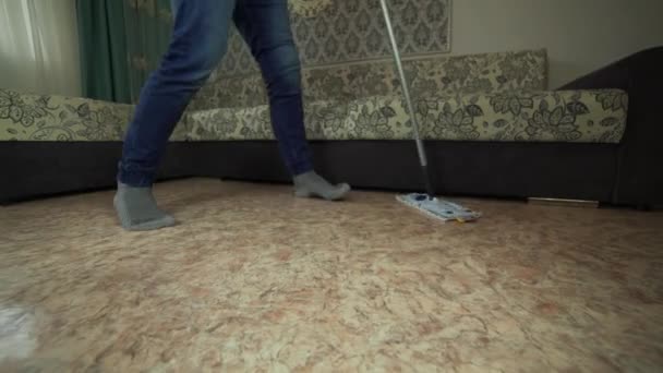Profesionální čištění podlah s Mop. Muž z úklidová firma umyje podlahu v obývacím pokoji. — Stock video