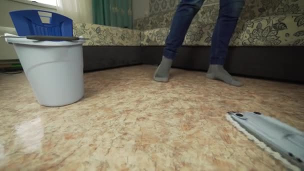 Profesionální čištění podlah s Mop. Muž z úklidová firma umyje podlahu v obývacím pokoji. — Stock video