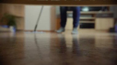 Profesyonel zemin paspası ile temizleme. Temizlik şirketinden bir adam oturma odasında yere yıkar.