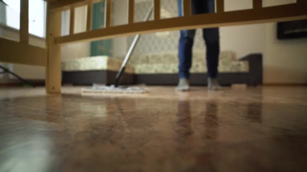 Pembersihan lantai profesional dengan MOP. Seorang pria dari perusahaan pembersih mencuci lantai di ruang tamu . — Stok Video