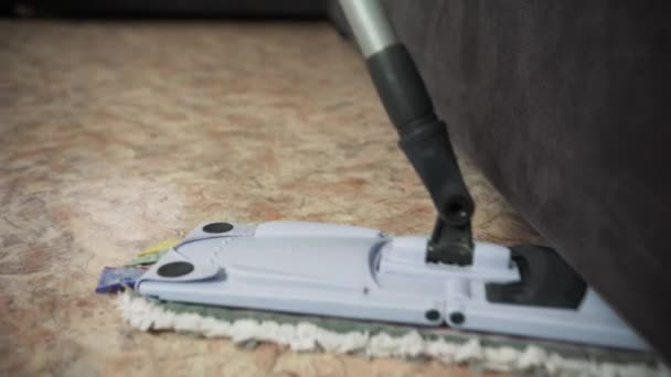 Professioneel vloer reinigen met een dweil. Een man uit het schoonmaakbedrijf wast de vloer in de woonkamer. — Stockvideo