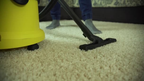 Aspirateur nettoie le tapis. Un homme d'une entreprise de nettoyage travaille, aspirant le tapis — Video