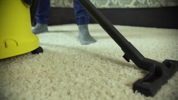 La aspiradora limpia la alfombra. Un hombre de una empresa de limpieza trabaja, aspirando la alfombra — Vídeos de Stock