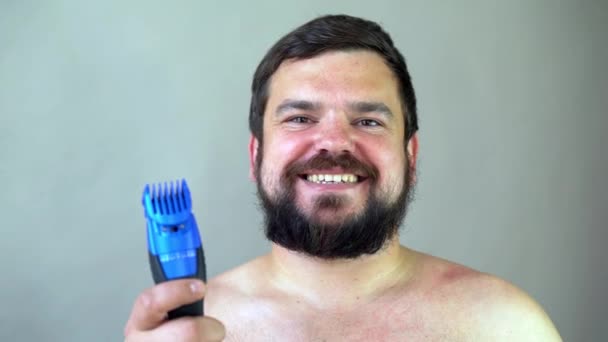 Muž začíná holit vousy strojem na holení. — Stock video
