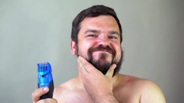 Man starting to shave beard with razor machine. — Stock Video