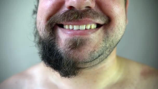 Concept beauté, toilettage et personnes - jeune homme regardant pour miroir et barbe à raser avec tondeuse ou rasoir électrique à la maison salle de bain — Video