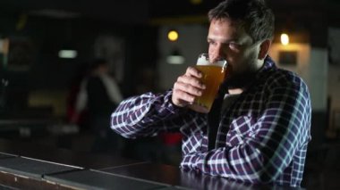 Bira içip pub barda bir içki tadını sakallı adam. Bir bardak bira erkek Konuk çalışır