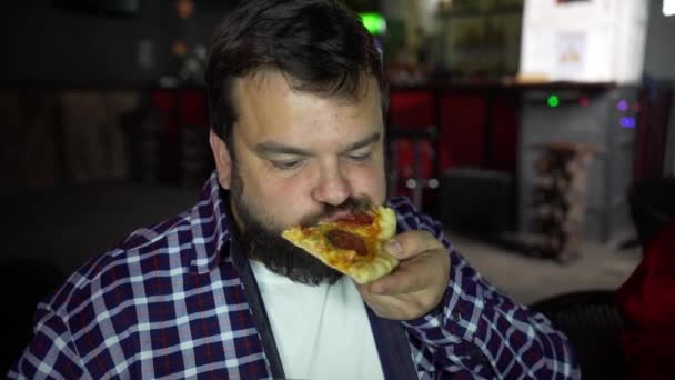 Бородатый мужчина ест пиццу — стоковое видео