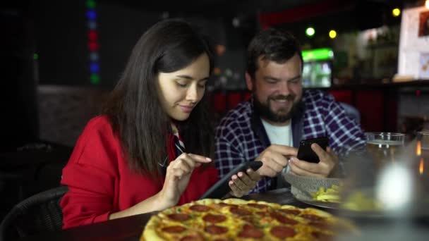 A garota no pub tira fotos de pizza no seu smartphone . — Vídeo de Stock