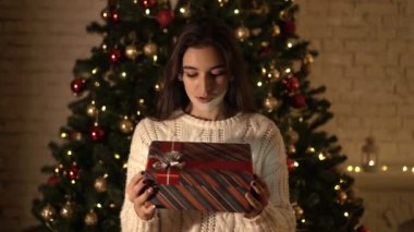Kadın bir yeni yıl hediye Noel ağacının altında açılır