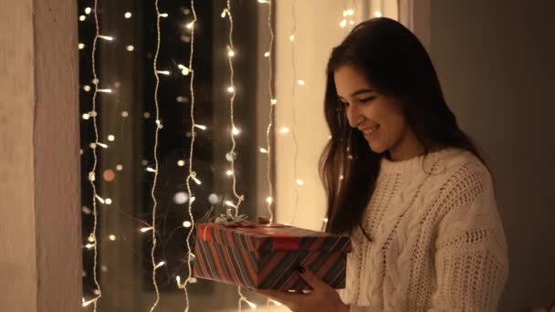 Femme ouvre un nouveau cadeau de l'année sous le sapin de Noël — Video