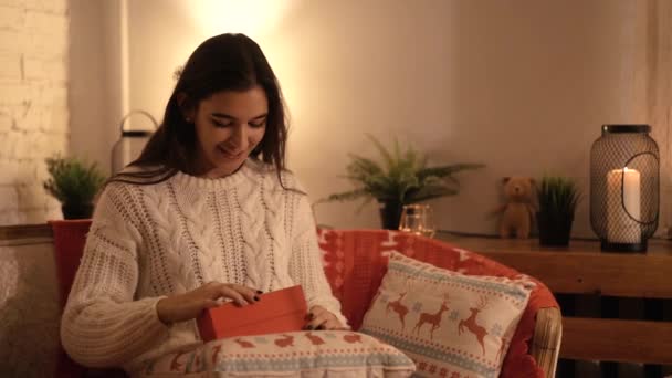 Mujer abre un regalo de año nuevo bajo el árbol de Navidad — Vídeos de Stock