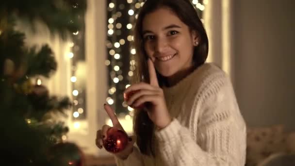 A lány díszíti a karácsonyfát. — Stock videók