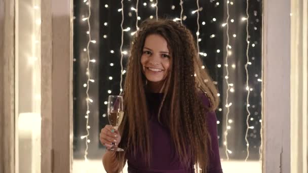 Девушка Бокалом Шампанского Поздравляет Новым Годом Фоне Гирлянды — стоковое видео
