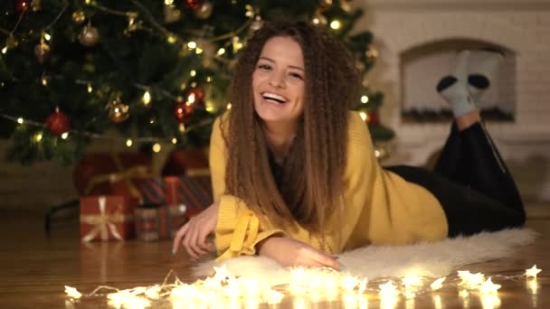 Дівчина пише лист до Санта-Клауса, на тлі новорічної ялинки — стокове відео