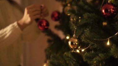 Kız Noel ağacını süslüyor.