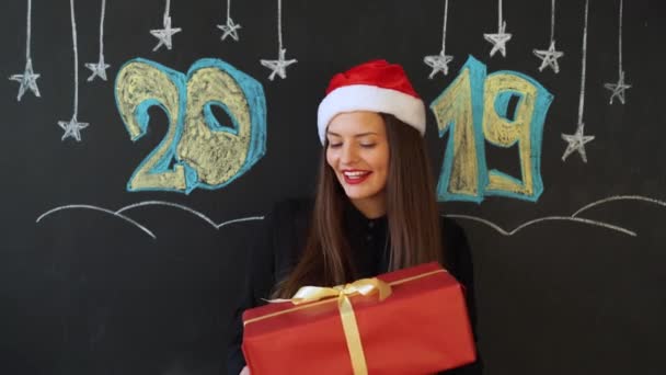 Девушка получает подарок на новый год, надпись 2019 — стоковое видео