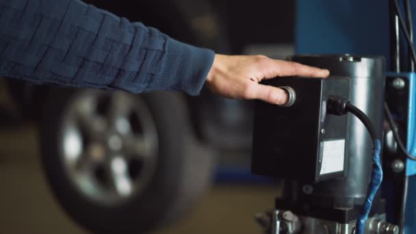 Giovane meccanico professionista solleva l'auto sul sollevatore per eseguire la diagnosi del telaio . — Video Stock