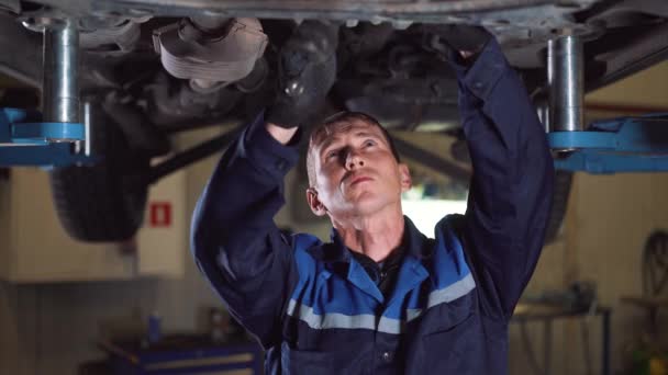 Servicio de automóviles, reparación, mantenimiento y concepto de personas - mecánico con llave inglesa y lámpara trabajando en el taller . — Vídeos de Stock