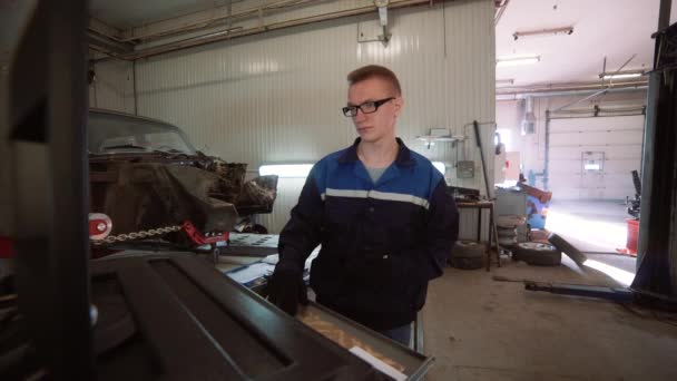 Mecánico que muestra al cliente el problema con el coche en el taller de reparación . — Vídeos de Stock