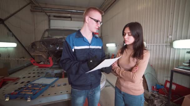 Monteur tonen klant het probleem met de auto bij de reparatiewerkplaats. — Stockvideo