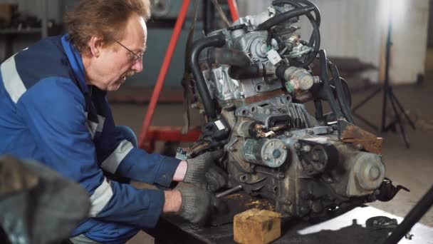 Επισκευή του κινητήρα του αυτοκινήτου, ο επισκευαστής ασχολείται με την αποκατάσταση του κινητήρα του κινητήρα — Αρχείο Βίντεο
